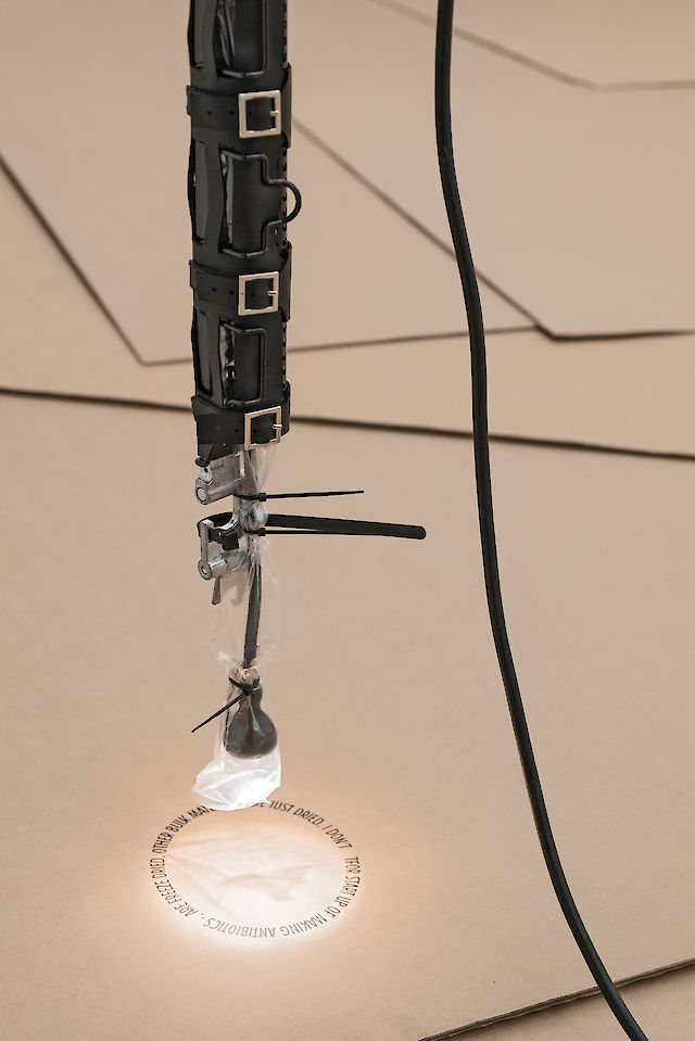 Ben Schumacher, One Calorie as Good as Another/​Epoch Defining Broadcast (black, thin), 2013, Lamp and original packaging, cable management arm and original packaging, leather case, 167&nbsp;×&nbsp;6 × 6&nbsp;cm