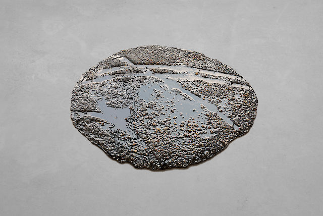 Marlie Mul, Puddle (Black Tracks), 2013, sand, stones, resin, 2 cm ø 60&nbsp;cm